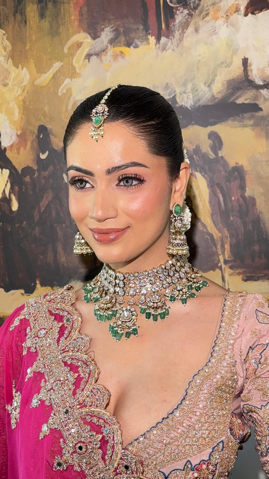 Cocktail makeup look by Surbhi Agarwal — bride in pink outfit with emerald jewelry
